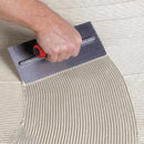Roberts 10-823 Comfort Grip 1/16" Square Notch Stainless Steel Trowel, in use