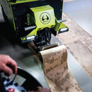 Front view of the Wolff Independence stripper removing flooring, with the operator holding the remote control